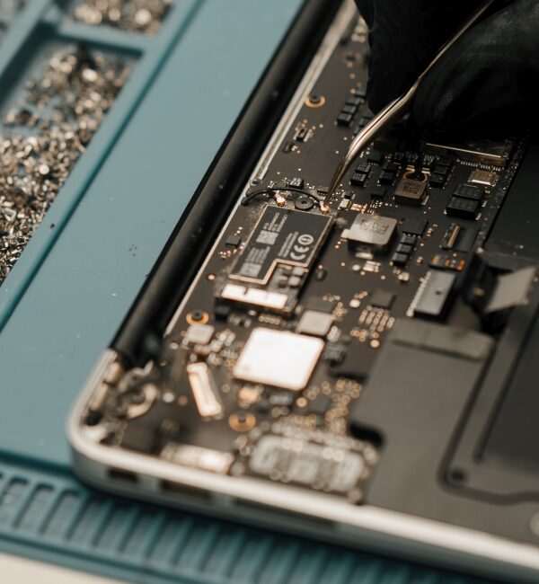 Technician engineer repairs or replaces new parts of broken and damaged laptop and tablet Workshop for repair of telephones and equipment computer boards and processors